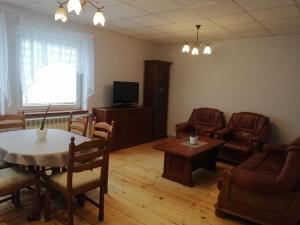 sala de estar con mesa, sillas y TV en Mieszkanie Nad Popradem INPIW03, en Piwniczna-Zdrój