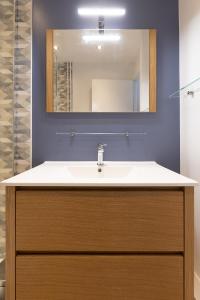 een badkamer met een wastafel en een spiegel bij Le petit Manhattan - Appartement privé de 45 m2 - 2 à 4 personnes - Parking privé in Metz