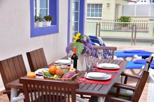 a wooden table with fruit and a bottle of wine at BEACH SIDE in Puerto de Mogán +46 photos