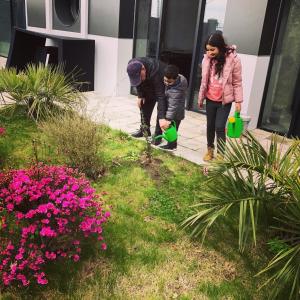 two adults and a child standing in a garden at OTAKHEBI in Sarpi