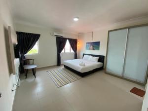 a bedroom with a bed and a large window at Tiara Desaru Resort in Desaru