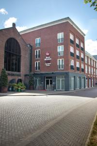 a large brick building on the side of a street at Best Western Plus City Hotel Gouda in Gouda