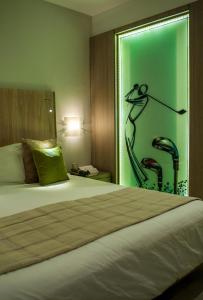 um quarto com uma cama com um quadro na parede em Golf Royal Hotel em Tunes