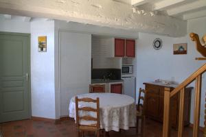 a kitchen with a table and a kitchen with a table and chairs at Chambre d hote La Roussiere in Saint-Ouen-des-Toits