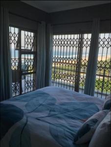 a bedroom with a bed with a view of the ocean at 53 Sancta Maria in Kingsburgh