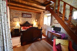 ein Schlafzimmer mit einem Bett in einer Steinmauer in der Unterkunft Quinta de Santa Baia in Gaifar