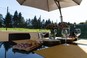 una mesa con copas de vino y comida. en Sweet Home a Vallefoglia by Yohome en Montecchio