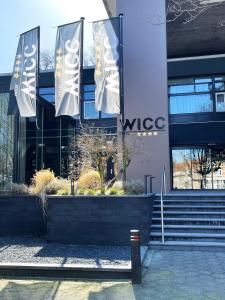 un edificio con dos banderas delante en Hotel WICC, en Wageningen