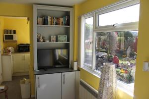 a kitchen with a large window and a television at The Garden Room Westcott in Westcott