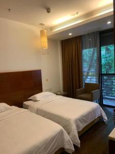 廣州的住宿－广州纺园公寓酒店，酒店客房,配有两张床和椅子