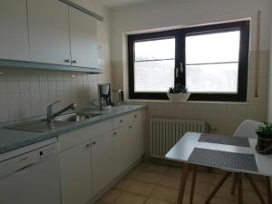 una cucina con lavandino, finestra e tavolo di FeWo mit Burgblick a Kreuzwertheim