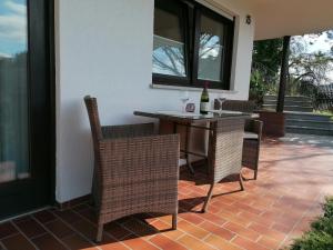 un patio con tavolo, sedie e bottiglia di vino di FeWo mit Burgblick a Kreuzwertheim