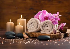 马泰兰Adamo the Resort的一个带蜡烛、毛巾和鲜花的spa套装