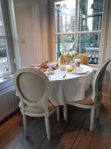 mesa de comedor con sillas y mantel blanco en "Het Steechje" in Ie bij Schiermonnikoog en Ameland, en Ee 12 fotos más