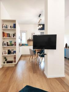 sala de estar con escritorio y TV de pantalla plana en Confortevole stanza privata in grazioso appartamento con giardino, en Cagliari