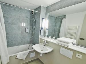 a bathroom with a sink, toilet and bathtub at Kyriad Chantilly Sud - Luzarches in Chaumontel