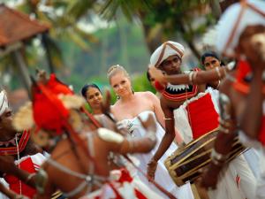 a bride and groom in front of a group of people at Hikka Tranz by Cinnamon in Hikkaduwa