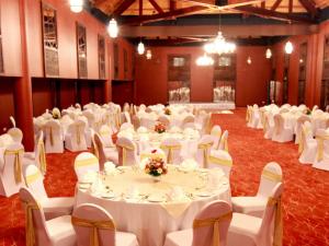 a banquet hall with white tables and chairs at Hikka Tranz by Cinnamon in Hikkaduwa