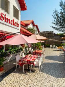 a patio with tables and umbrellas in front of a building at Sinclair Guest House in Abuja