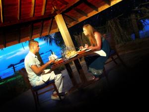 a man and a woman sitting at a table at Hikka Tranz by Cinnamon in Hikkaduwa