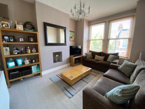 a living room with a couch and a coffee table at 3 bed Apartment in Colliers Wood in London