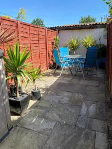 a patio with blue chairs and a table and a fence at 3 bed Apartment in Colliers Wood in London