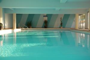 a swimming pool with a blue tub and a blue chair at Hotel Europa in Quiberon