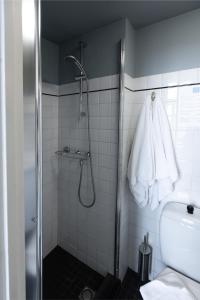 a bathroom with a shower with a toilet and a towel at Boutique hotel Puur Zee - Adults Only in Wijk aan Zee