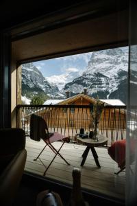 a balcony with a table and a view of a mountain at Bergwelt Grindelwald - Alpine Design Resort in Grindelwald