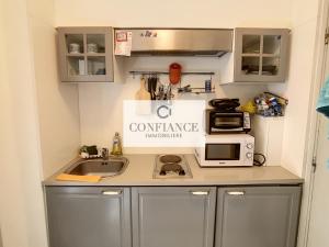 a small kitchen with a sink and a microwave at Amiral de Grasse in Nice