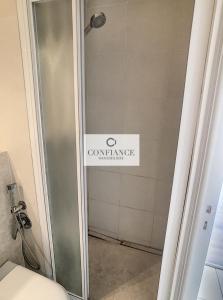 a bathroom with a shower with a sign on the wall at Amiral de Grasse in Nice