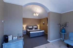 - une chambre avec un lit et une chaise bleue dans l'établissement Boutique hotel Puur Zee - Adults Only, à Wijk aan Zee