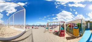 un parque infantil en la arena de la playa en Hotel Biancaneve Wellness, en Marotta