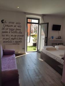 Schlafzimmer mit einem Bett und einer Glasschiebetür in der Unterkunft Antica Campione Rooms & Hostel in Campione del Garda