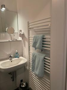 a white bathroom with a sink and a mirror at Weinhaus an der Bergstrasse in Hamburg