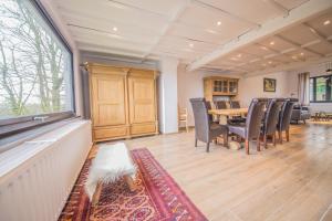 a dining room with a table and chairs and a window at La villa Émilie in Durbuy
