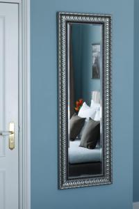 a mirror in a silver frame on a door at Boutique hotel Puur Zee - Adults Only in Wijk aan Zee