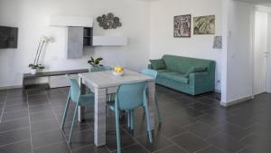 eine Küche und ein Wohnzimmer mit Tisch und Stühlen in der Unterkunft Luminosa - Cala Gonone in Cala Gonone