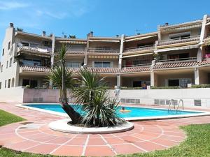 坎布里爾斯的住宿－Dorado frente playa cambrils，一座大型建筑,在一座建筑前设有一个游泳池