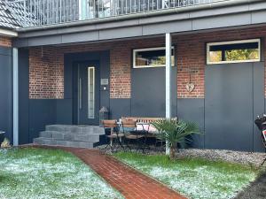 ein Haus mit einer Veranda mit einer Bank und einem Tisch in der Unterkunft Weinhaus an der Bergstrasse in Hamburg