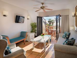 a living room with a table and chairs at Regency Country Club, Apartments Suites in Playa de las Americas