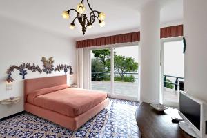 een slaapkamer met een bed en een groot raam bij Villa Felicita in Massa Lubrense