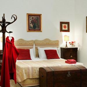 a bedroom with a large bed with red pillows at Villa il Pozzo in Certaldo