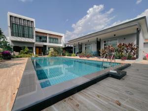 a swimming pool in front of a house at Lotus Lake View in Ban Bua