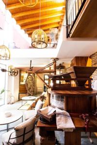 ein Wohnzimmer mit einem Tisch, Stühlen und einer Treppe in der Unterkunft Molino Candeal Hotel Boutique & Apartamentos in Caniles