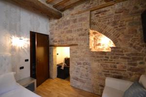 a room with a brick wall with a fireplace at Case Brizi Assisi in Assisi