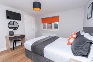 a bedroom with a bed and a desk with a mirror at Stable Court Apartments in Antrim