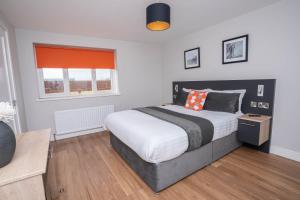 a bedroom with a large bed and a window at Stable Court Apartments in Antrim