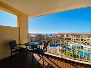 プラヤ・デ・ラス・アメリカスにあるCoral Compostela Beach, private apartmentのプールの景色を望むバルコニー(テーブル、椅子付)