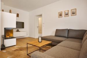 een woonkamer met een bank en een salontafel bij die Tauplitz Lodges - Bergblick Lodge B1 by AA Holiday Homes in Tauplitz